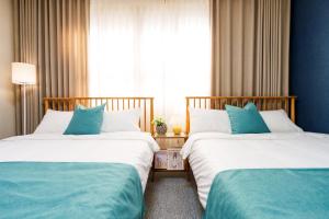 two beds sitting next to each other in a room at Open#Dongdaegu Station#Luggage Storage#Maximum 8 people#Sensational Accommodation#Hotel Bedding#Silent Fan#1st Floor House in Daegu
