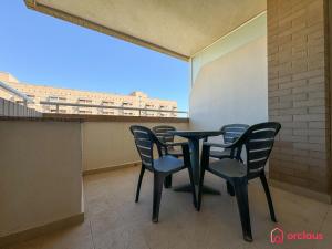 a table and chairs on a balcony with a large window at Rincón Ideal in Oropesa del Mar