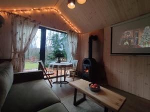 a living room with a couch and a wood stove at Namelis Eglių pasaka in Stripiniai