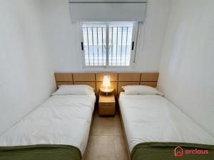 two beds in a small room with a window at Rincón Ideal in Oropesa del Mar