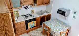 a small kitchen with a stove and a table at Casa del Vecchio Borgo in Caccamo