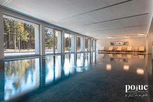 a swimming pool with tables and chairs in a building at Rêve Blanc - Poluc Apartments bilocale in Champoluc