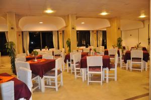 a dining room with tables and white chairs at Shady Hotel Luxor in Luxor