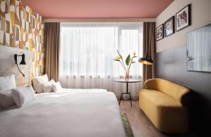 a hotel room with a bed and a chair and a window at NYX Hotel Berlin Köpenick by Leonardo Hotels in Berlin +57 photos