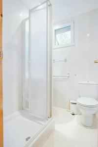 a white bathroom with a toilet and a shower at Olympia by Cardi Suites in Formigal +38 photos