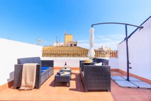 a patio with chairs and a table on a roof at Merceria 4 by Unik Vacation in Tarragona