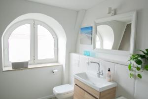 a white bathroom with a sink and a toilet at Hans & Franz Zimmervermietung in Schwerin +68 photos