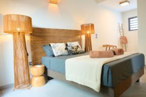 a bedroom with a bed with two lamps on it at Villa Zarlor - 6 voyageurs in Petite Île +43 photos