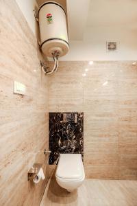 a bathroom with a toilet and a light on the ceiling at Pax Hotel Spring Solance in Dalhousie