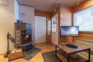 a living room with a fireplace and a tv at Kuukkeli Apartments Suite in Saariselka +40 photos