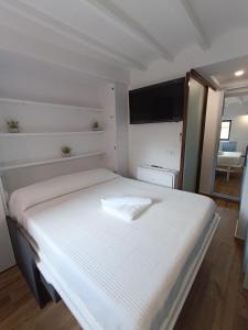 a white bed in a room with a television at Bobal - Harbor's Light in Villajoyosa