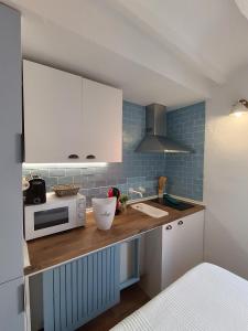 a kitchen with a counter with a sink and a microwave at Bobal - Harbor's Light in Villajoyosa