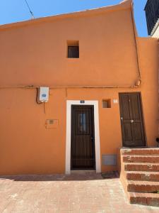 an orange building with two doors on the side at Bobal - Harbor's Light in Villajoyosa
