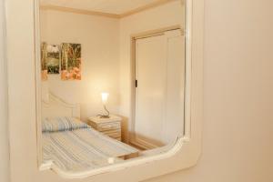 einen Spiegel in einem Zimmer mit einem Bett und einer Lampe in der Unterkunft Quinta das Acácias in Livramento + 114 Fotos