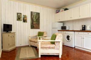 eine Küche mit Tisch und Stuhl und einer Mikrowelle in der Unterkunft Quinta das Acácias in Livramento