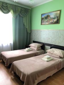 two beds in a room with green walls at Готель Оазис in Chernivtsi