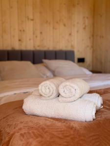 two rolled towels sitting on top of a bed at Stodoły Słona Zatoka in Władysławowo