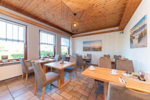 a restaurant with wooden ceilings and tables and chairs at Hotel Villa Sonneck-Adults Only in Sankt Peter-Ording