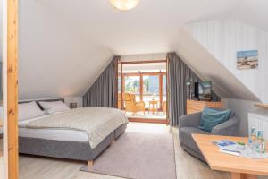 a bedroom with a bed and a living room at Hotel Villa Sonneck-Adults Only in Sankt Peter-Ording