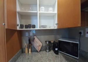 a kitchen counter with a microwave and some cups and utensils at Bay Square studio Bay view in Dubai