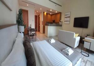a living room with a large bed and a kitchen at Bay Square studio Bay view in Dubai