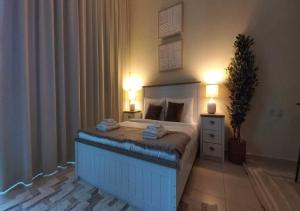 a bedroom with a bed with two lamps and a plant at Bay Square studio Bay view in Dubai