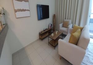 a living room with a couch and a tv at Bay Square studio Bay view in Dubai