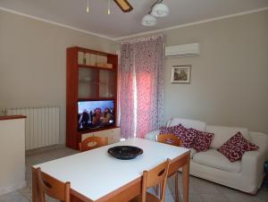 a living room with a white table and a couch at Aurora and Brothers' home in Falerna Marina