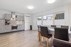 ルストにあるApartments Münchbach - near Europa-Park and Rulanticaのテーブルと椅子のあるキッチンとダイニングルーム