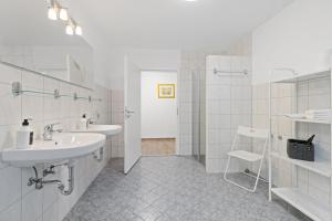 ルストにあるApartments Münchbach - near Europa-Park and Rulanticaの洗面台2つとシャワー付きの白いバスルーム