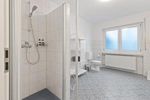 ルストにあるApartments Münchbach - near Europa-Park and Rulanticaのシャワーとトイレ付きの白いバスルーム