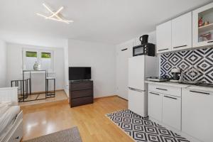 una cucina con armadi bianchi e neri e bianchi di M B Homes Schlatt Fewo 1 a Hechingen