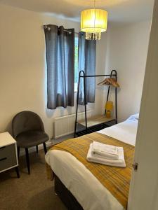 a bedroom with a bed and a chair and a window at Central Chester Apartment, 2 beds, 3 guests in Chester