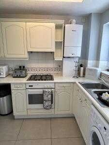 a kitchen with white cabinets and a stove and refrigerator at Central Chester Apartment, 2 beds, 3 guests in Chester +4 photos