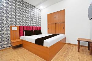 a bedroom with a large bed and a desk at Super Hotel O Sunshine Villa in Nagpur +22 photos