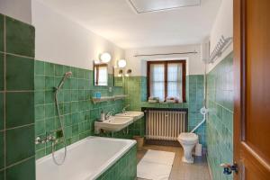 une salle de bain avec une baignoire, un lavabo et des toilettes dans l'établissement Ferienhaus Sonnenleitn, à Lenggries 24 autres photos