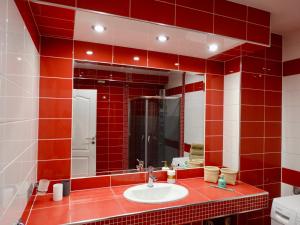 a red tiled bathroom with a sink and a mirror at Apartmani Maris in Neum +26 photos