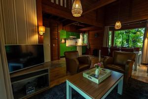 Una sala de estar con un televisor grande y una mesa. en Vacation Home North Limburg, en Blitterswijck