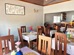 a restaurant with tables and chairs with people sitting at them at HOTEL MAA MEVFOU Hmm in Yaoundé