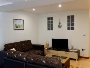 a living room with a couch and a tv at Apartmani Maris in Neum