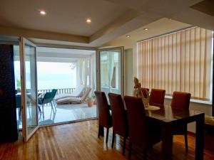 a dining room with a table and chairs and a balcony at Apartmani Maris in Neum