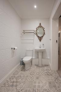 a white bathroom with a toilet and a sink at Stirling Townhouse Apartment Btm in Stirling +32 photos