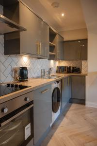 a kitchen with stainless steel cabinets and a washer and dryer at Stirling Townhouse Apartment Btm in Stirling +32 photos