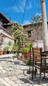 a wooden bench sitting in front of a building at Hava Baci (old town) in Berat