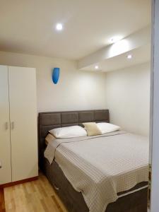 a bedroom with a bed with a blue object on the wall at Apartmani Maris in Neum