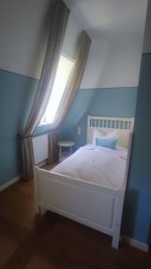 a bedroom with a white bed with a window at Schlosshotel Hohenbocka in Hohenbocka