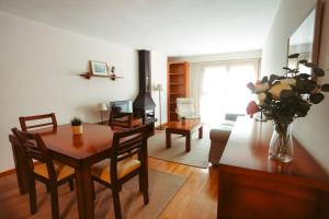 a living room with a table and a couch at Fuente Espadilla by Cardi Suites in Sallent de Gállego