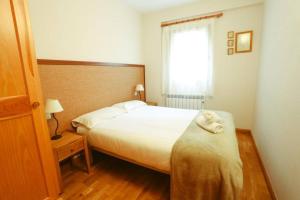 a bedroom with a bed with a towel on it at Fuente Espadilla by Cardi Suites in Sallent de Gállego