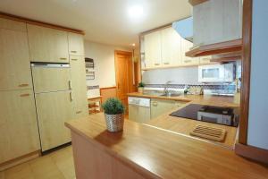 a kitchen with a wooden counter top in a room at Fuente Espadilla by Cardi Suites in Sallent de Gállego +3 photos