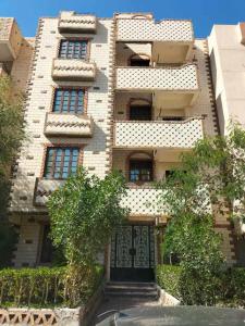 a large brick building with a gate in front of it at Horus apartment in Al Bayāḑīyah
